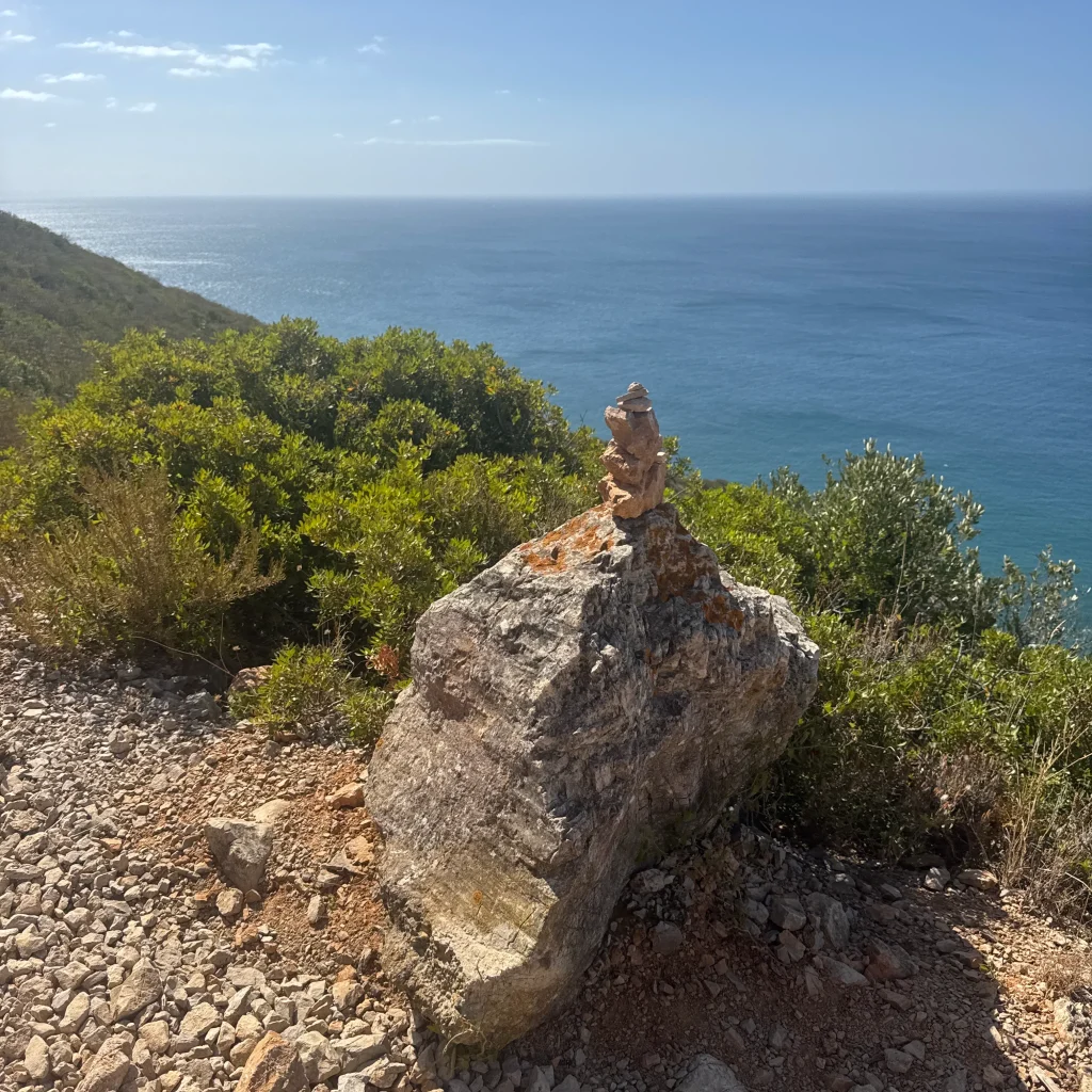 Hito de piedras en el sendero de aproximación a la Vía Ferrata Caminho do Mar en Arrábida